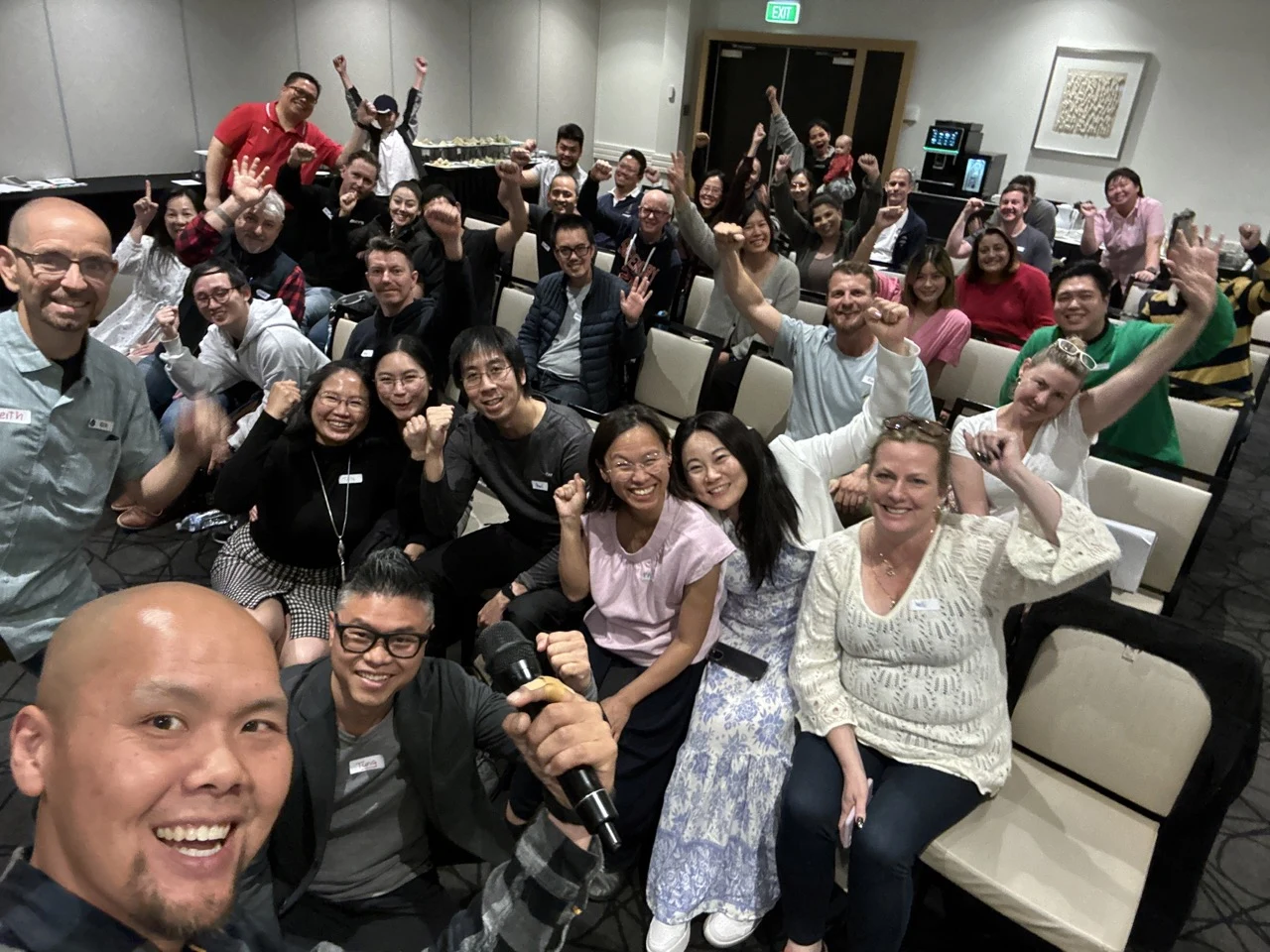 FAT FIRE community members smiling and waving together at a conference