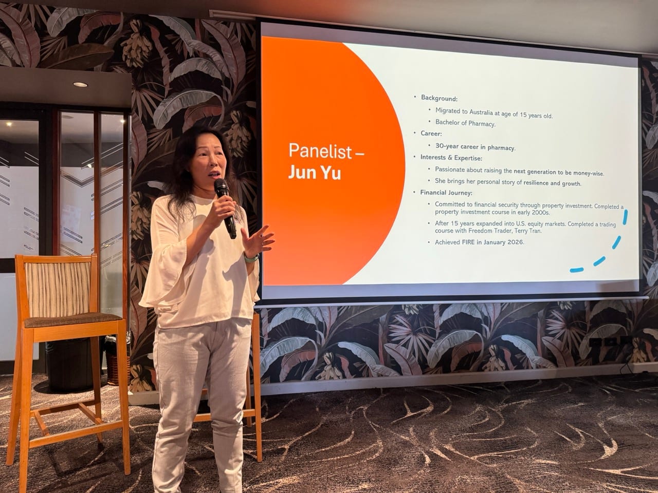 Panelist Jun Yu speaking in front of her introduction slide